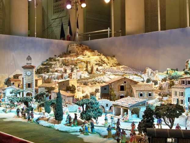 Ausstellung im Museum mit detaillierter Darstellung einer Krippe mit Figuren, Strukturen und beleuchteten Elementen.