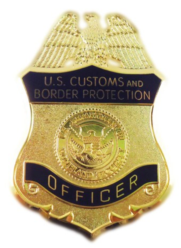 Ein goldener Abzeichen mit der Aufschrift "U.S. Customs and Border Protection Officer" auf einem weißen Hintergrund.