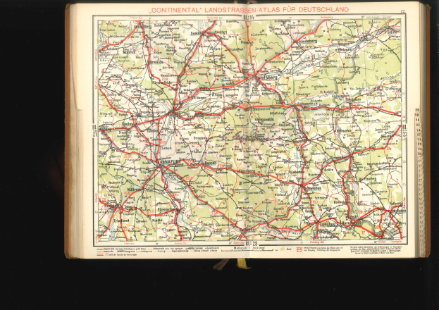 Offenes Buch mit detaillierter Karte von Deutschlands Straßen und Autobahnen auf schwarzem Hintergrund.