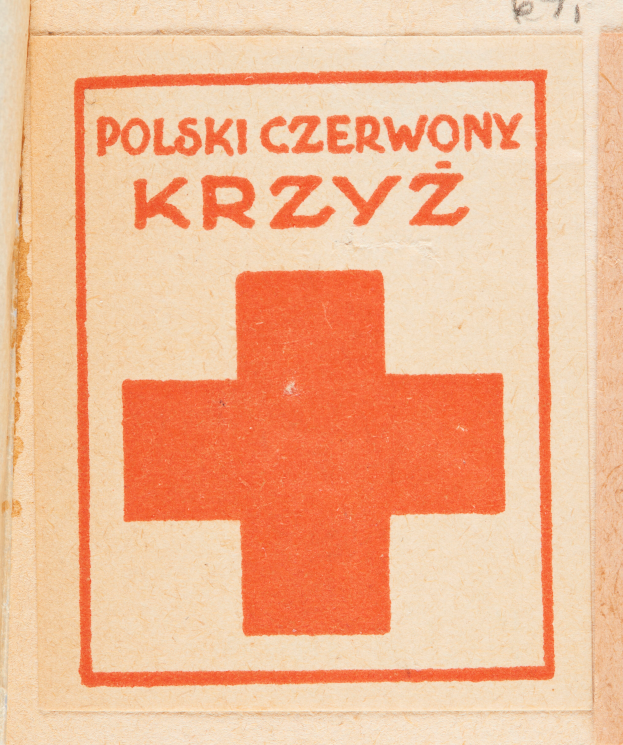 Ein altes Buch mit einem roten Kreuz und einem Pluszeichen auf dem Cover, wahrscheinlich ein Verbandskasten, mit Text darauf.