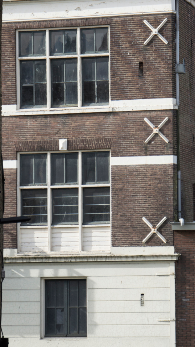 Ein Gebäude mit mehreren Fenstern und sichtbaren Rohren an der Außenseite.