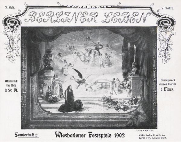 Schwarz-weiß-Foto einer Bühne mit Darstellern in traditioneller deutscher Tracht, beschriftet mit "Wiesbadener Festspiele 1902", und einem applaudierenden Publikum im Hintergrund.