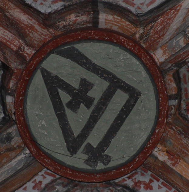 Ein Wandbild mit einem schwarzen und weißen Kreis mit einem roten Kreuz in der Mitte, umgeben von einem weißen Rand, vor einem hellblauen Hintergrund.