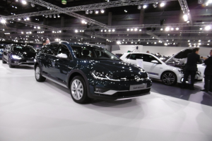 Ein Volkswagen Golf Alltrack auf der IAA in Frankfurt, umgeben von Menschen und beleuchtet von Deckenlampen.