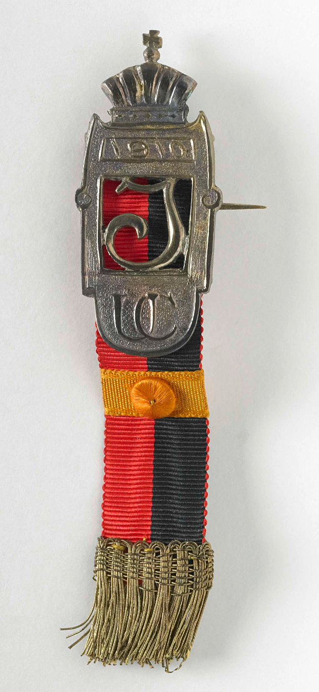 Ein silbergoldenes und rotes Band mit einer Krone darauf, das das Ordensband des Sterns des Deutschen Reiches von 1919 darstellt, mit einem Abzeichen in rot, schwarz, gelb und silbern auf einem weißen Hintergrund.