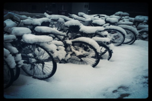 Mehrere Fahrräder liegen auf dem Boden, alle mit Schnee bedeckt.