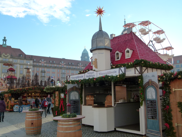 Ein lebendiger Weihnachtsmarkt in Nürnberg, Deutschland, mit Menschen um geschmückte Stände, Gebäuden, einem Riesenrad und einem bewölkten Himmel, mit einer Tafel auf der rechten Seite.