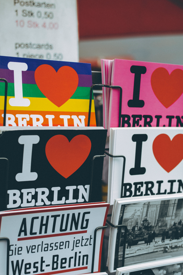 Ein Gestell mit verschiedenen Büchern und Postern, auf denen 'I Love Berlin' steht, mit einem unscharfen Hintergrund, der einen träumerischen Effekt erzeugt.