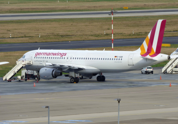 Germanwings Airbus A320-200 am Frankfurter Flughafen mit Bodenfahrzeugen, Verkehrskegeln, Pfählen und Gras im Hintergrund geparkt.