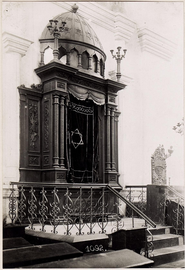 Ein altes Schwarz-Weiß-Foto einer jüdischen Synagoge in New York City, das eine Treppe, Geländer, Säulen, eine Tür und eine Wand zeigt, mit dem Text 'Jüdische Synagoge in New York City' unten.