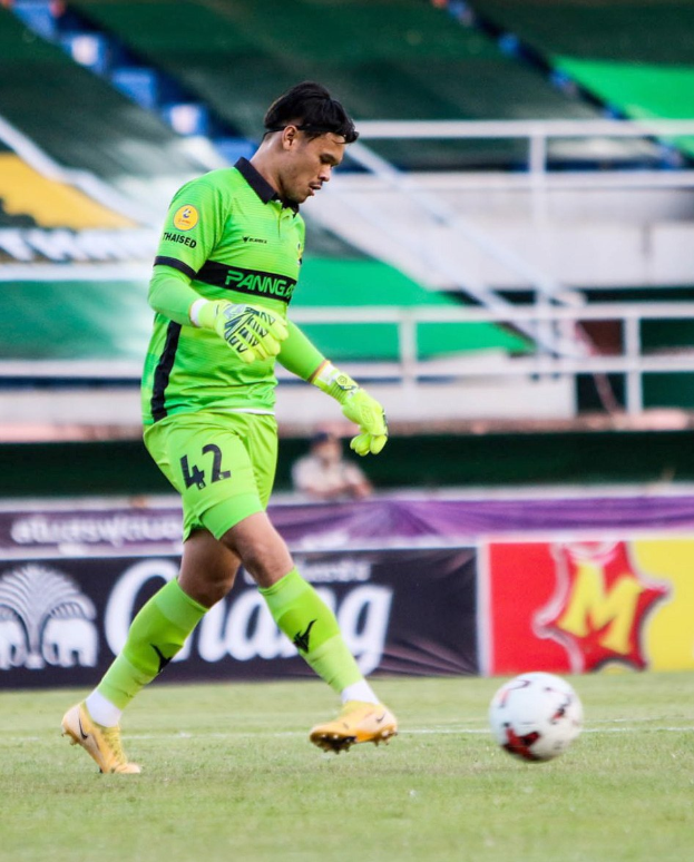 Ein Torwart in grüner Uniform kickt einen Fußball auf einem Rasenfeld während eines Spiels zwischen Chivas USA und Mexico City in der Copa Libertadores, wie durch Banner im Hintergrund angezeigt.
