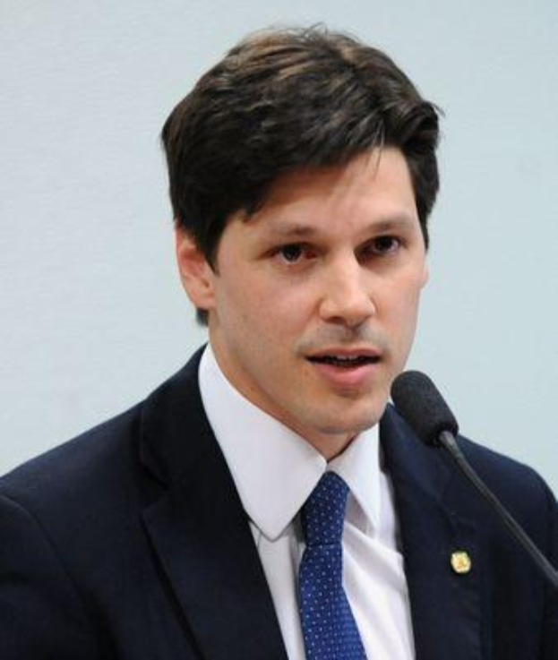 Ein Mann im Anzug und mit Krawatte spricht in ein Mikrofon, wahrscheinlich um die Genehmigung eines Gesetzes zur Verbots des Internetgebrauchs durch die Regierung zu kommentieren.