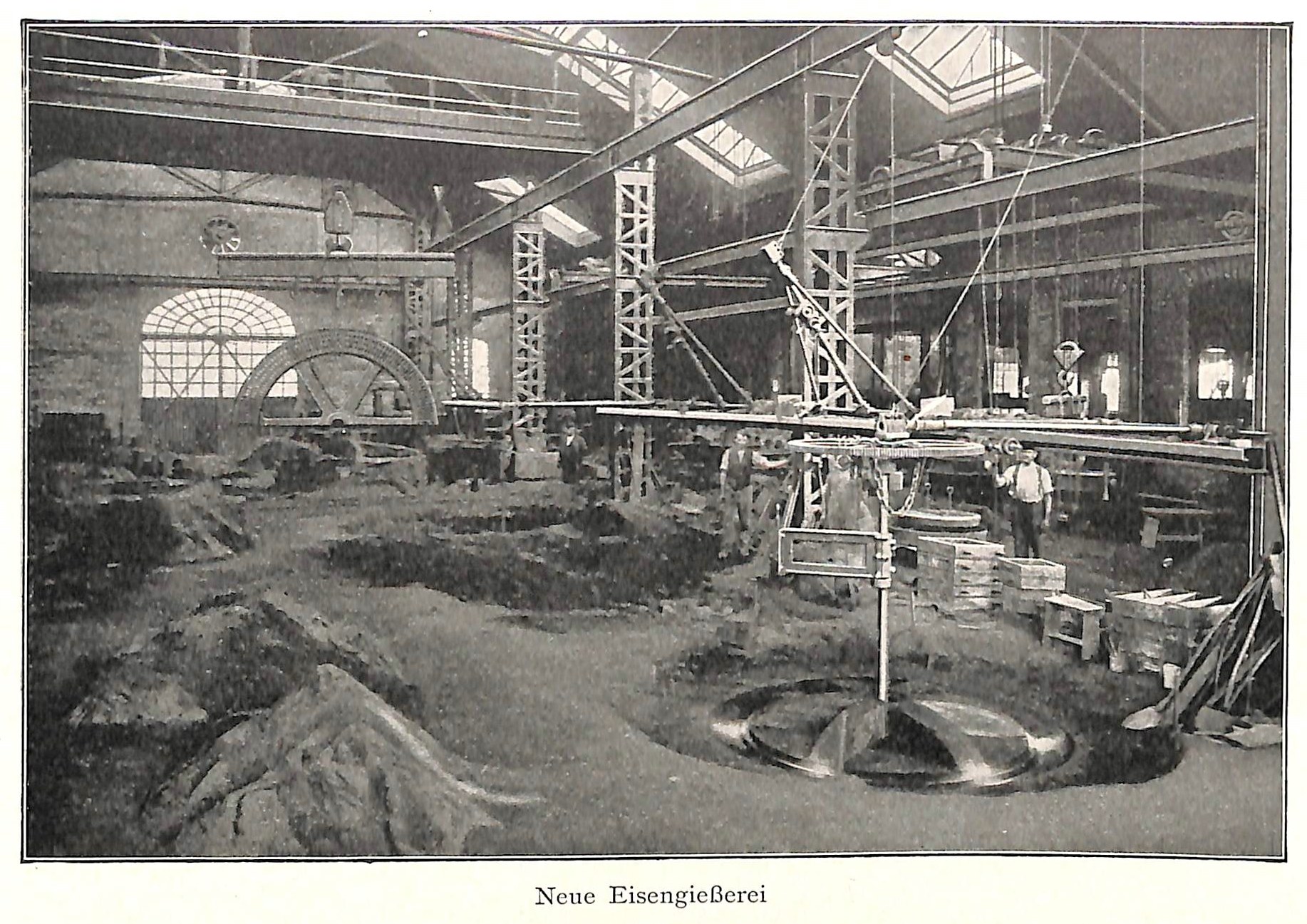 Schwarzes und weißes Foto einer Fabrikhalle mit Arbeitern, die Maschinen bedienen, Metallstangen und -stangen, beschriftet mit "Neue Eisenglebeerei, die erste Fabrik in Deutschland" unten.