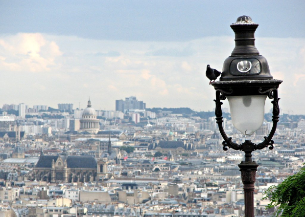 Eine Vogelperspektive einer Stadtlandschaft mit Gebäuden und einem schwarzen und weißen Laternenpfahl im Vordergrund.
