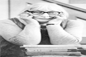 Ein Schwarz-Weiß-Bild einer Frau vor einem Bücherstapel.