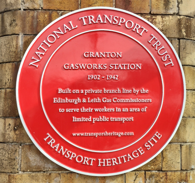 Runder roter Schild an einem Backsteinbau mit "National Transport Trust"-Text.