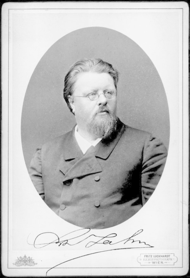 Ein Schwarz-Weiß-Foto eines bärdigen Mannes in einem Mantel und mit Brille, mit dem Text "Fritz Luckhardt, Gründer der Deutschen Kommunistischen Partei" unten.