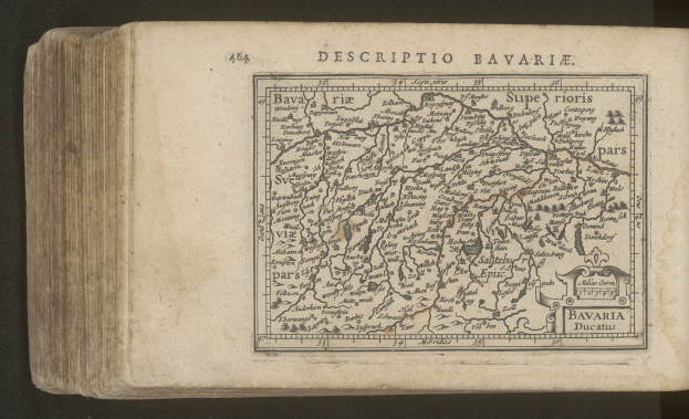 Altes Buch mit einem detaillierten Kartenbild von Bayern auf dem Cover, vor einem schwarzen Hintergrund.