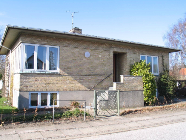 Außenansicht eines frei stehenden Zweifamilienhauses mit zwei Schlafzimmern zum Verkauf in St. Johns Wood, Swindon, mit Dach, Fenstern, Tür, Treppe, Metallzaun, Pflanzen, Gras, Bäumen, Satellitenschüssel und bewölktem Himmel.