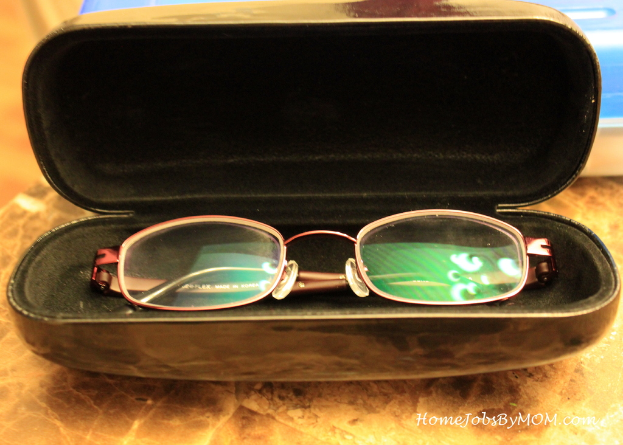 Eine Brille wird in eine offene Brillenbox gelegt.