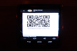 Ein Mobiltelefon mit einem QR-Code auf dem Bildschirm.
