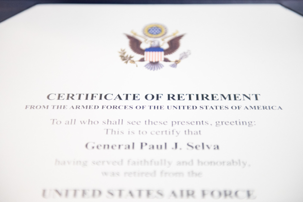 Rahmenurkunde für den Ruhestand von der United States Air Force mit blauem Rand, die ein zentrales Sternschild-Logo innerhalb eines Lorbeerkranzes und eine "Ruhestand"-Bannerschrift in schwarzer Tinte zeigt.