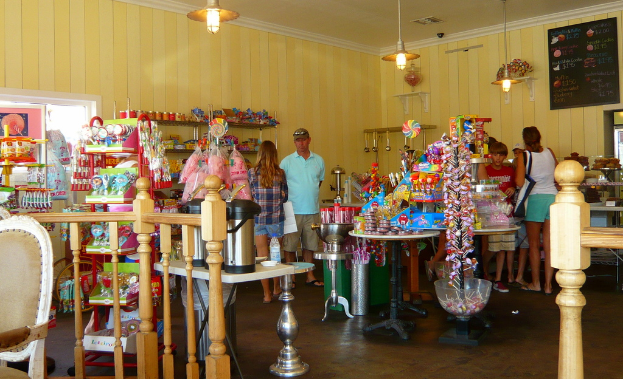 Eine Gruppe von Menschen vor einem Geschäft mit Bonbons, Süßigkeiten und Backwaren.