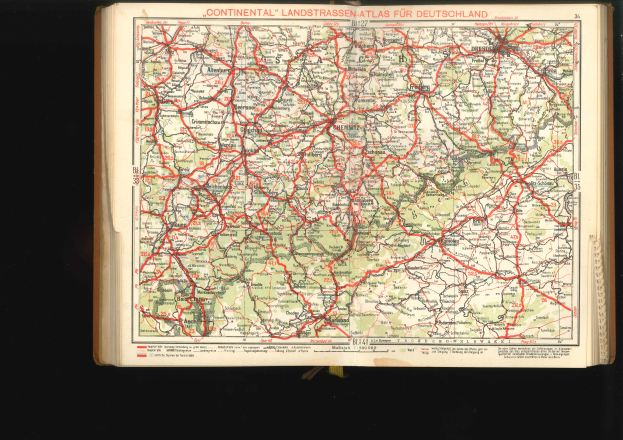 Offenes Buch mit einem detaillierten Straßen- und Autobahnplan von Deutschland auf schwarzem Hintergrund.