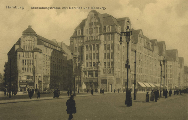 Ein altes Schwarz-Weiß-Foto von Menschen, die auf einer bewölkten Straße in Hamburg, Deutschland, entlanggehen, gesäumt von Gebäuden, Straßenlaternen, Straßenlaternen und Kraftfahrzeugen, mit Text oben.