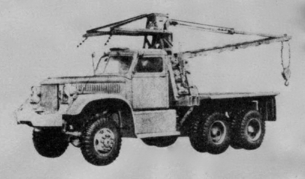 Schwarzes und weißes Foto eines großen, vierrädrigen Truck mit einem Kran auf dem Rücken und einem flachen Anhänger, der angeblich das erste Schwerlastfahrzeug der Welt ist.