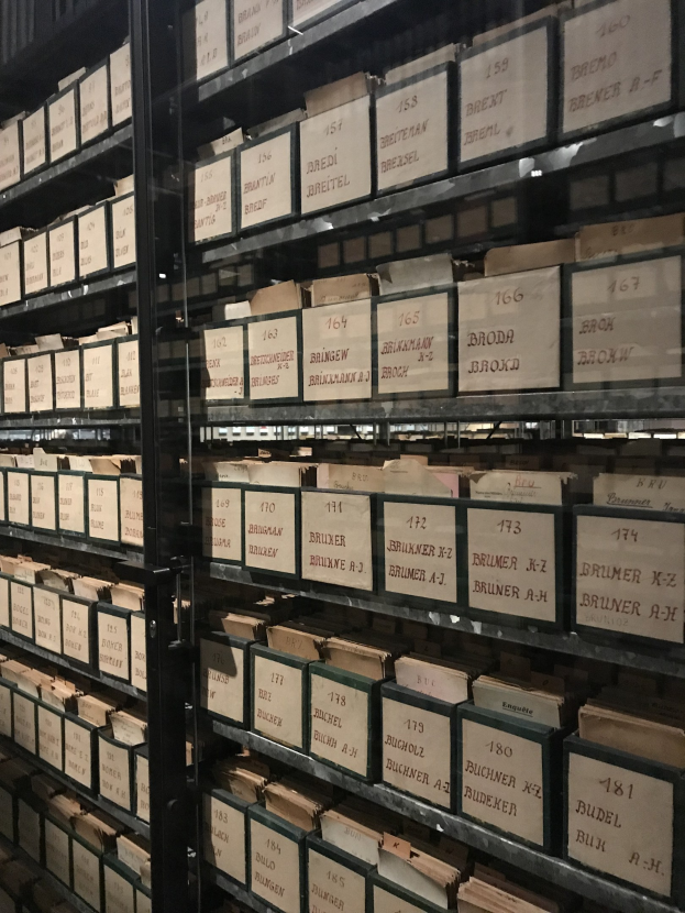 Großes Lager mit ordentlich gestapelten Kisten, jede Kiste mit bedrucktem Text beschriftet.