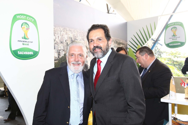 Eine Gruppe von Menschen, die mit einigen lächeln, ein FIFA-Weltmeisterschaftsposter im Hintergrund.