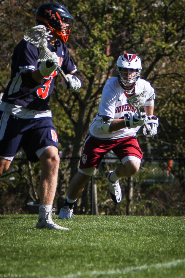 Zwei Spieler mit Helmen und Bats auf einem Feld mit Bäumen im Hintergrund.